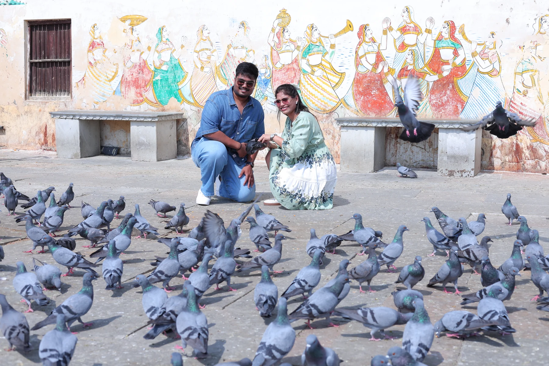 Rohan and Ritika together in a courtyard with pigeons.