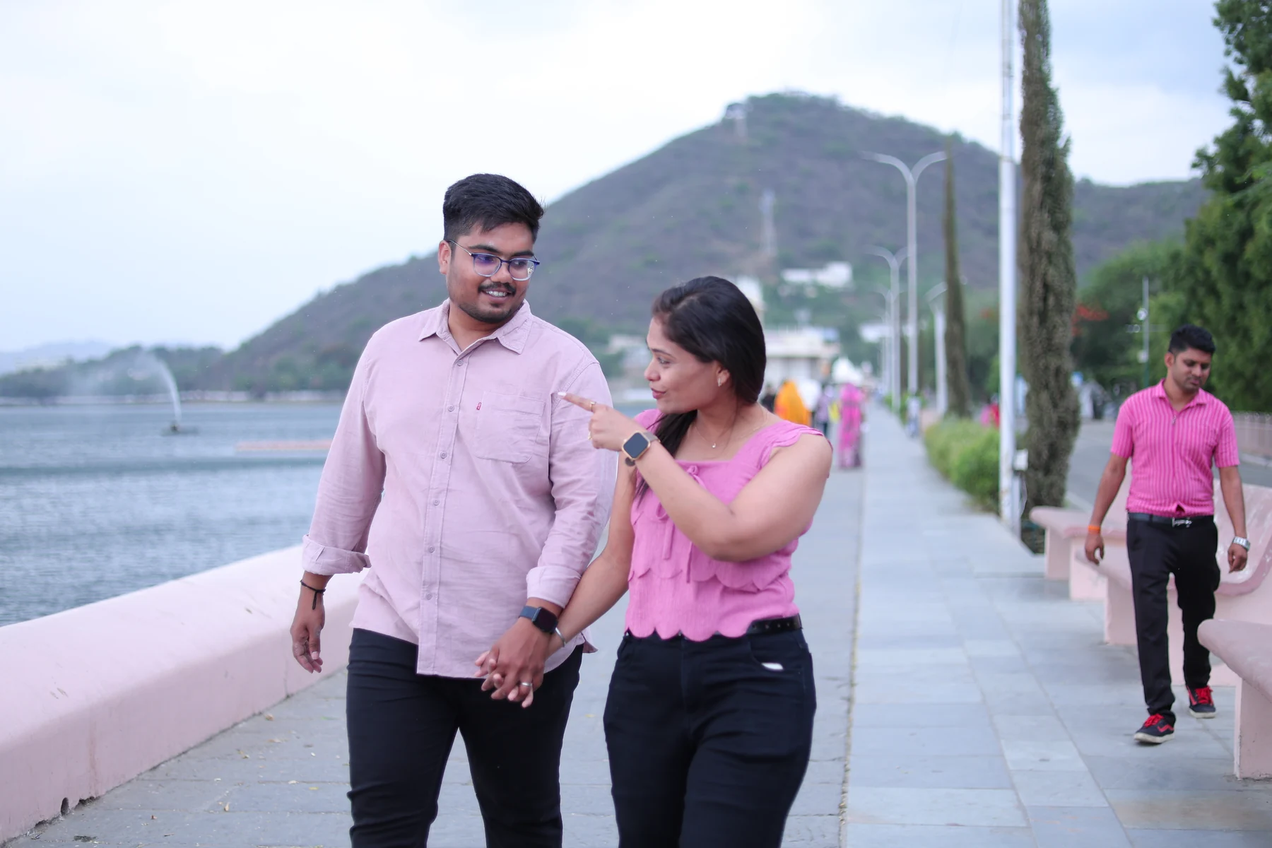 Rohan and Ritika holding hands by the lake.